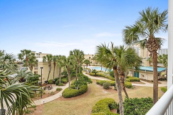 Silver Dunes courtyard view with palm trees, pool and landscaped grounds